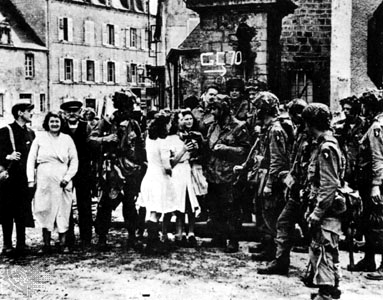 U.S. 101st Paratroopers enjoying the welcome and hospitallity of villagers following their liberation of St. Marie du Mont